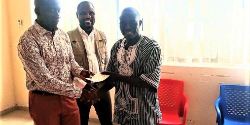 Minister of Transport, Hon. Samuel A. Wlue presenting a check to NAFOMTAL