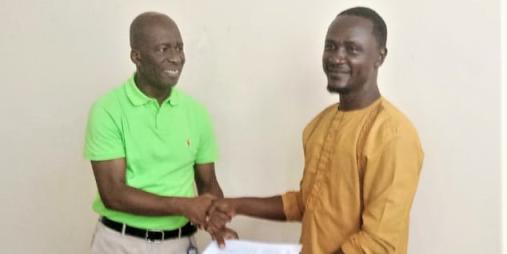 Transport Minister, Hon. Samuel A. Wlue presents the MOU onbehalf of GOL, Samuel Deapah, President General receives onbehalf of the Union.